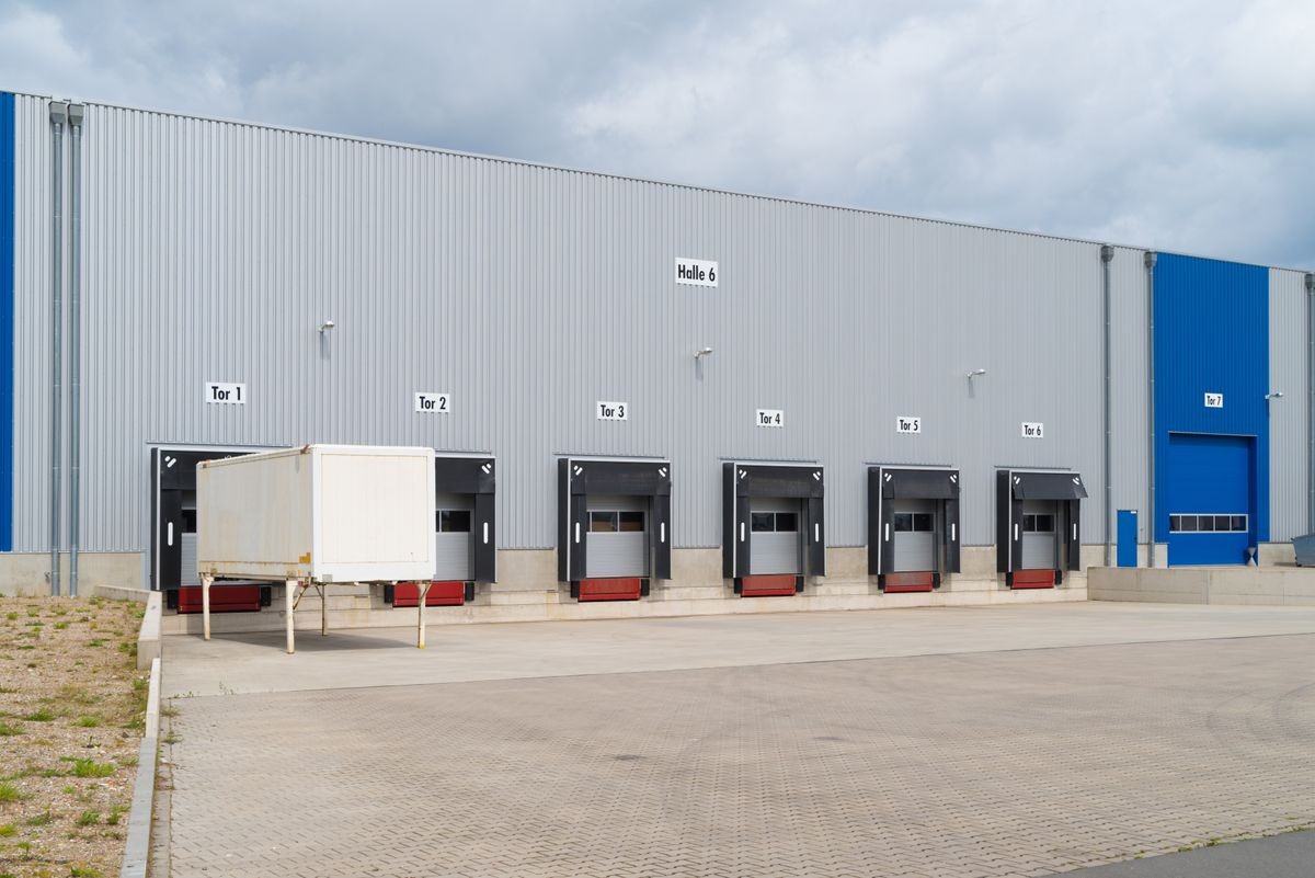 row of loading docks and a trailer at a large commercial warehouse in germany